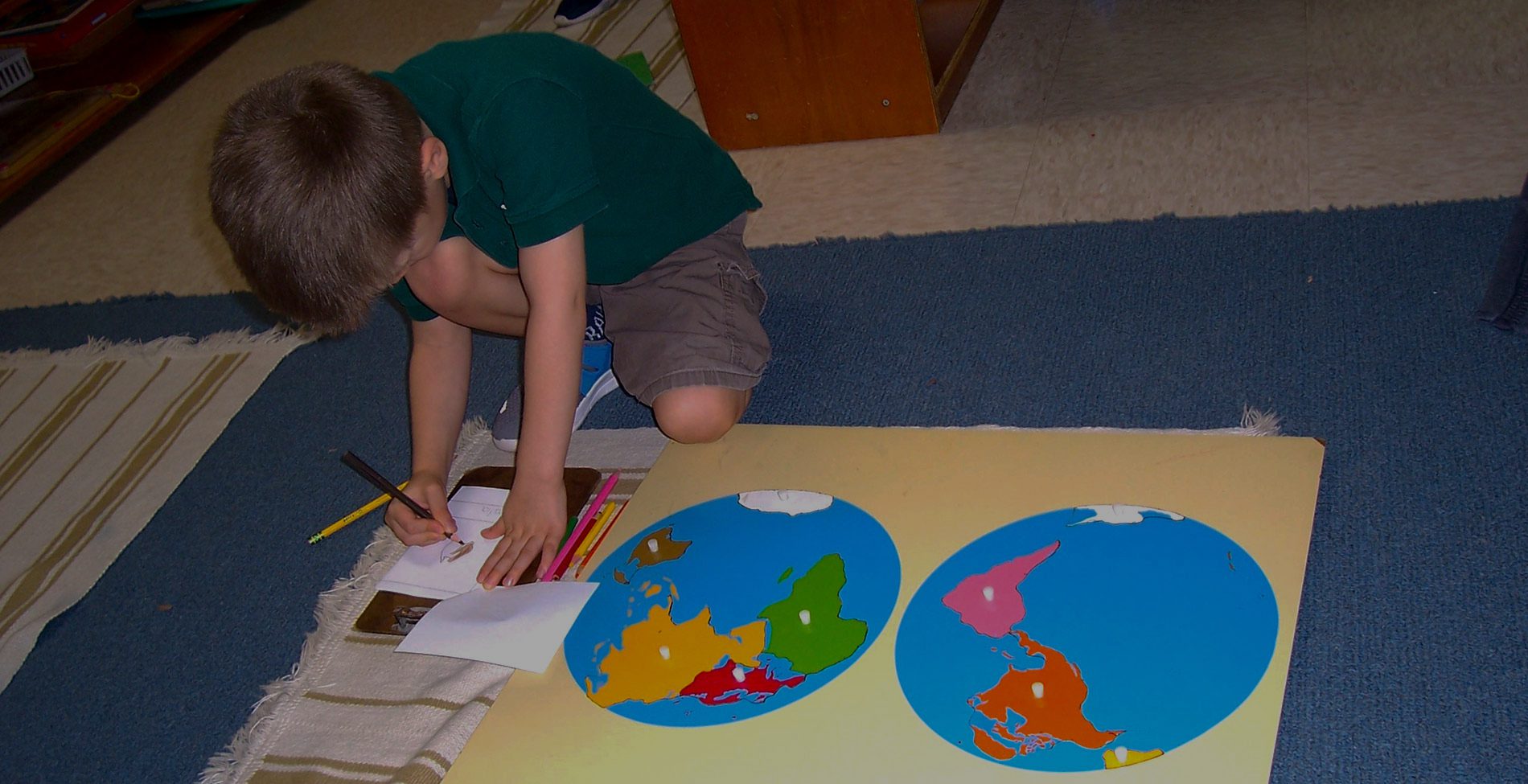 A student using a globe as an activity at Sugar Mill Montessori School