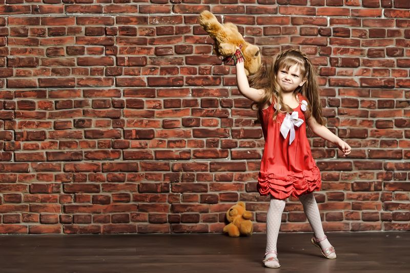 Girl throwing teddy bear