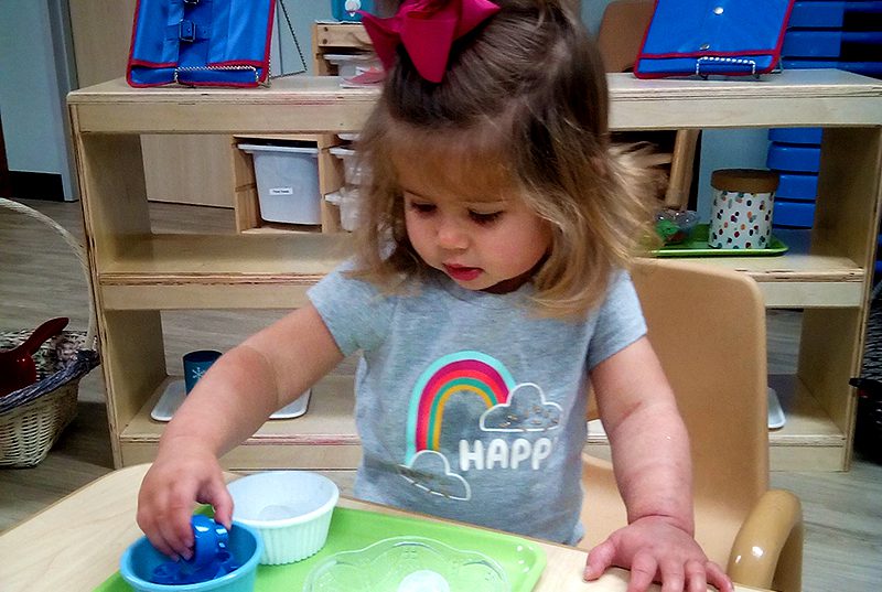 Toddler at Sugar Mill Montessori School playing with play-dough