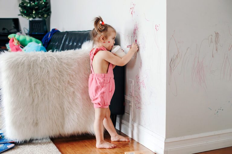 Young girl drawing on the walls
